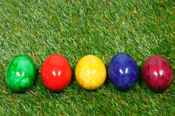 Colorful eggs lie on a synthetic grass — Stock Photo, Image