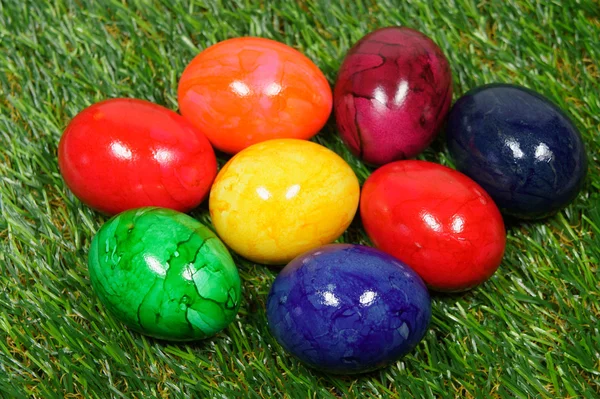 Colorful eggs lie on a synthetic grass — Stock Photo, Image