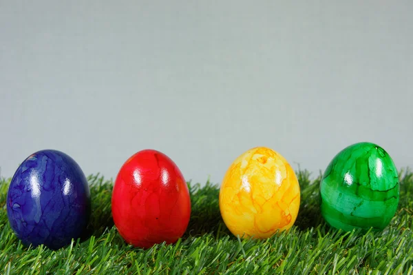 Huevos de Pascua coloridos en un césped de verde artificial — Foto de Stock