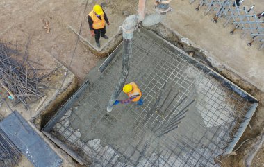 İnşaat alanına beton döken hava manzaralı inşaat işçisi seçilmiş odak çekimi