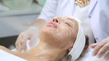 Yüz soyma maskesi, kaplıca güzellik tedavisi, cilt bakımı. Güzellik salonunda yüz bakımı yaptıran bir kadın. Güzel bir kadın güzellik merkezinde yüz masajı yaptırıyor.