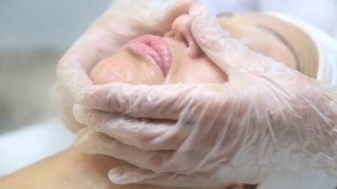Yüz soyma maskesi, kaplıca güzellik tedavisi, cilt bakımı. Güzellik salonunda yüz bakımı yaptıran bir kadın. Güzel bir kadın güzellik merkezinde yüz masajı yaptırıyor.