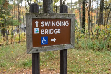 Minnesota, ABD - 6 Ekim 2021: Sonbahar sezonunda Jay Cooke Eyalet Parkı 'ndaki Sallanan Köprü için yön işareti