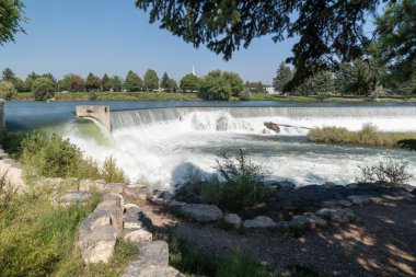 Idaho Şelalesi nehir kıyısında barajı ve şelalesi olan, arkasında Mormon tapınağı olan bir yer.