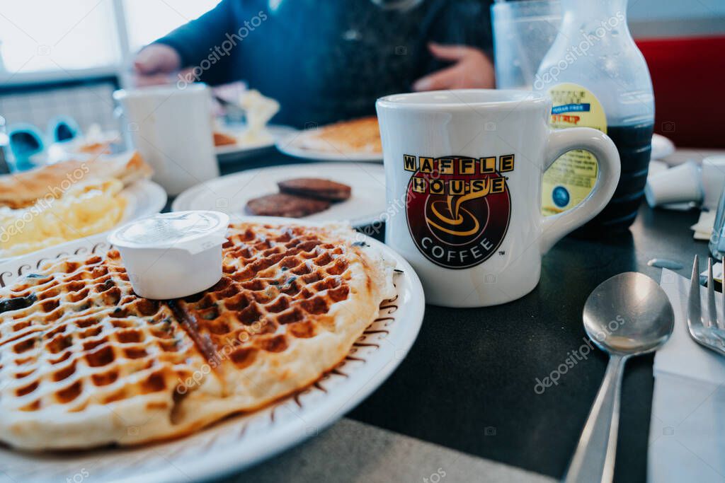 Calvert City, Kentucky - January 10, 2022: Breakfast meal at a Waffle House restaurant, serving breakfast all day. Focus on the coffee cup
