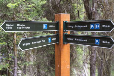 Banff, Alberta, Canada - July 10, 2022: Directional sign in Johnston Canyon, shows hikes distances to Upper Falls and the parking lot