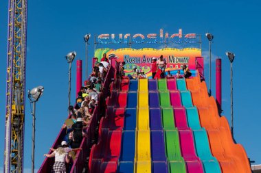 Calgary, Alberta, Canada - July 16, 2022: Riders enjoy using the giant slide, known as the Euroslide at the midway at the Calgary Stampede