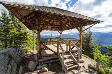 Small hut shelter at the top of Big Beehive in Banff National Park, hiker makes his way