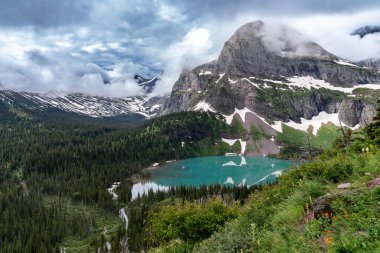 Buzul Ulusal Parkı 'nda Grinnell Gölü bulutlu bir yaz gününde dramatik bulutlarla