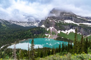 Buzul Ulusal Parkı 'nda Grinnell Gölü bulutlu bir yaz gününde dramatik bulutlarla