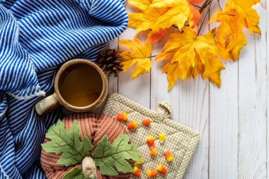 Mavi ve beyaz çizgili battaniye, balkabağı, beyaz ahşap arka planda mısır şekeri