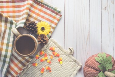 Kareli kumaş havlu, balkabağı, beyaz ahşap arka planda mısır şekeri.