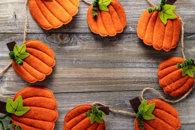 Turuncu balkabaklarının ahşap bir arka planda daire şeklinde dizildiğini hissettim. Sonbahar ve sonbahar projeleri için tepeden aşağı düz görünüm