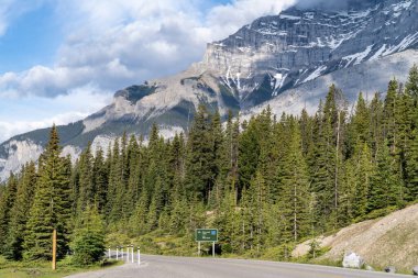 Banff Ulusal Parkı 'ndaki İki Jack Gölü' ne giden yolun etrafındaki çarpıcı dağlar.