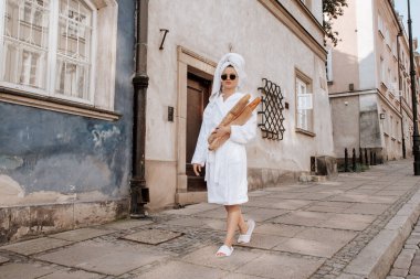 Varşova 'da caddede duran Fransız ekmeği alan şık bir kadın..