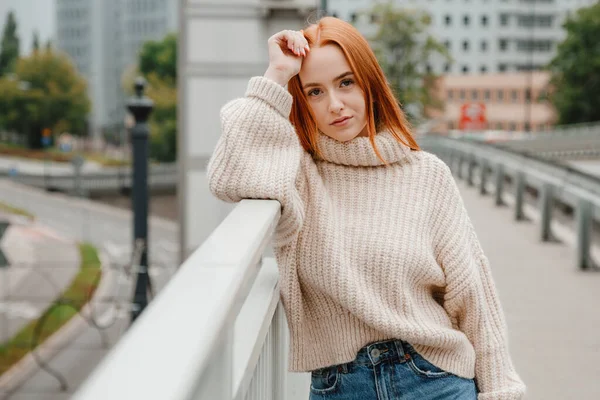 Открытый портрет девушки, стоящей на лестнице возле моста в Варшаве. Портрет девушки на мосту на улице. Привлекательная европейская женщина в свитере и берете исследует страну в отпуске. — стоковое фото