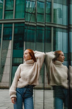 Başarılı mutlu kadın portresi işe giderken yolda. Şehir sokaklarında poz veren çok uzun saçlı, güzel, doğal kızıl saçlı bir kızın açık hava portresi. Uzun kızıl saçlı moda kızı..