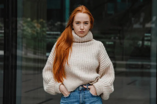 Portrait d'une femme heureuse qui réussit sur le chemin du travail dans la rue. Portrait extérieur de jeune belle rousse naturelle, cheveux très longs, posant dans la rue de la ville. Fille de la mode avec de longs cheveux rouges. Images De Stock Libres De Droits