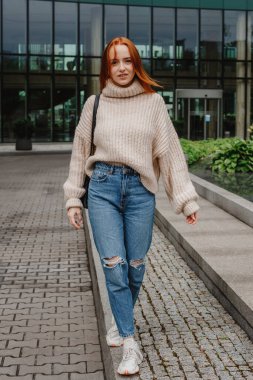 Başarılı mutlu kadın portresi işe giderken yolda. Şehir sokaklarında poz veren çok uzun saçlı, güzel, doğal kızıl saçlı bir kızın açık hava portresi. Uzun kızıl saçlı moda kızı..