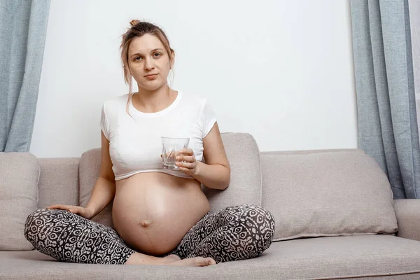 Schwangere Mit Einem Glas Wasser Auf Dem Sofa Zimmer Ziemlich — Stockfoto