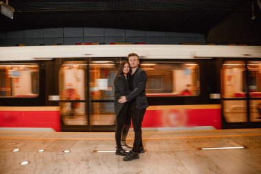 Metroda vagonun yanında yürürken el ele tutuşan çift. Çift metroyu kullanarak şehri gezip geziyor. Seyahat.