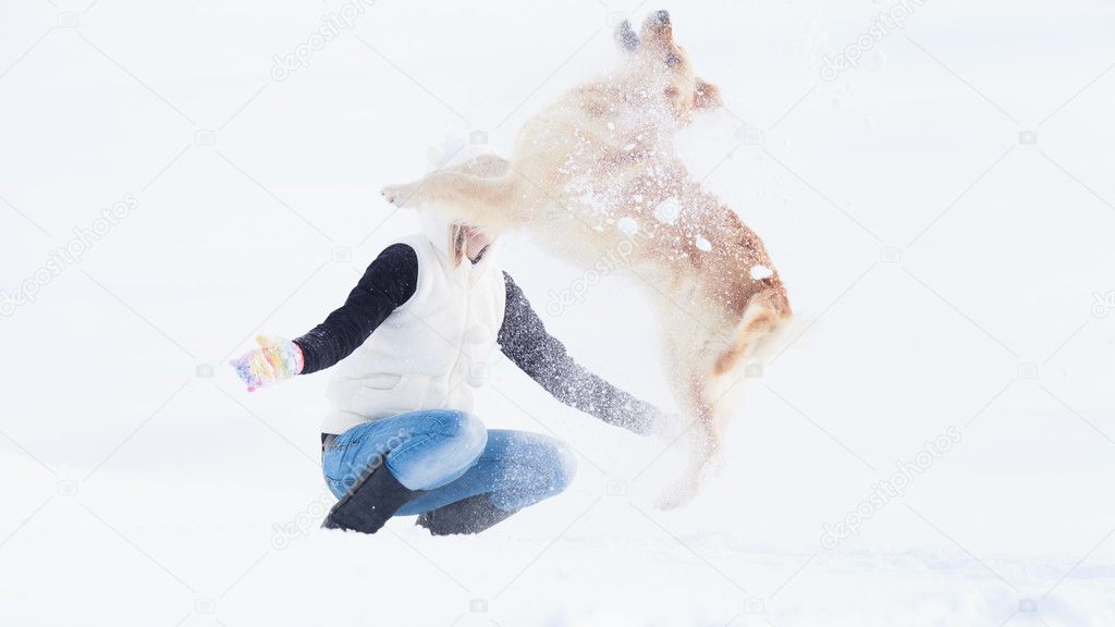 Girl with her dog playing in winter outdoors. Labrador Retriever