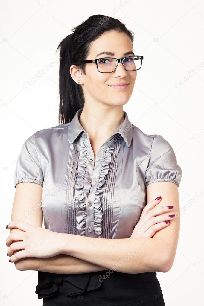 Portrait of a happy young confident business woman standing with folded hands against white background