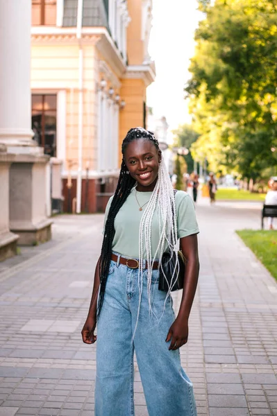 Beautiful young black woman walking at street.