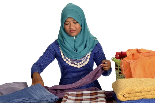 Молодая мусульманка складывает одежду — стоковое фото