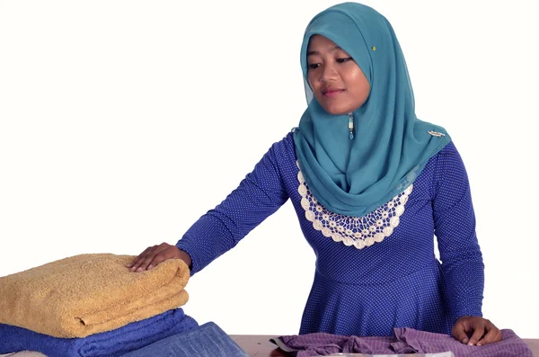 Menina muçulmana organizando roupas — Fotografia de Stock