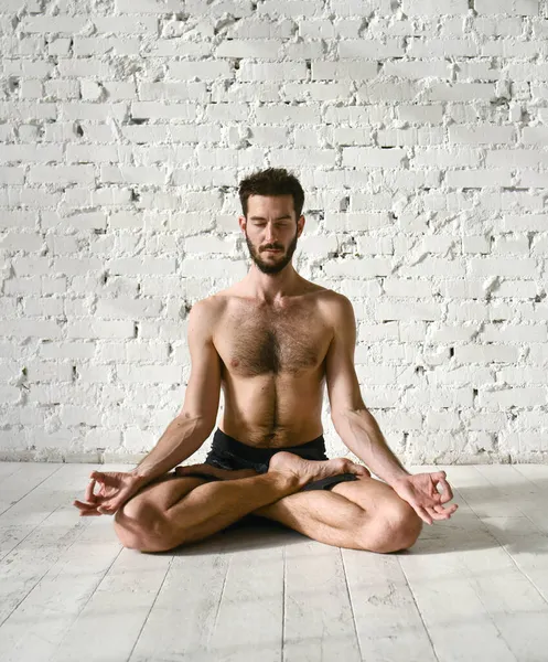 Genç bir adam yoga yapıyor. Yoga koçu hafif arka planda. Telifsiz Stok Fotoğraflar