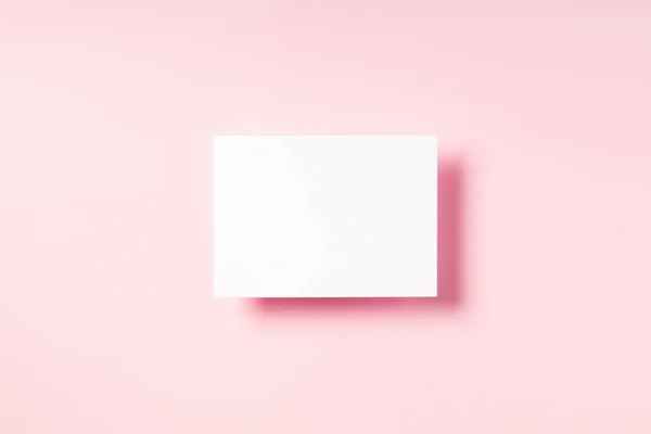 Fondo rosa pastel con postal blanca en blanco. —  Fotos de Stock