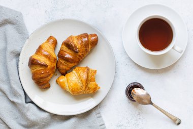 Kahvaltı sahnesi. Kruvasan tabakta ve bir fincan çay.
