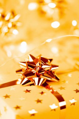 Altın fiyonklu ve kurdeleli paketlenmiş Noel hediyesi kutuları.