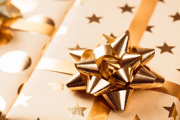 Altın fiyonklu ve kurdeleli paketlenmiş Noel hediyesi kutuları. — Stok fotoğraf