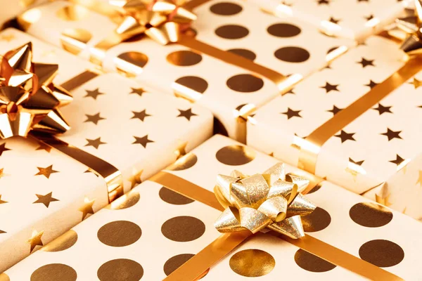 Altın fiyonklu ve kurdeleli paketlenmiş Noel hediyesi kutuları. — Stok fotoğraf