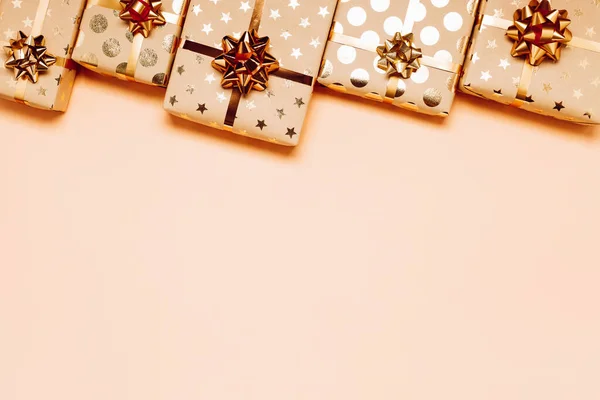 Geschenkdozen met gouden strikken op beige ondergrond. — Stockfoto