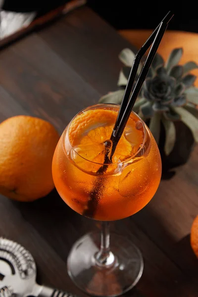 Aperol Spritz deasupra pe un fundal din lemn cu o portocalie în fundal — Fotografie, imagine de stoc