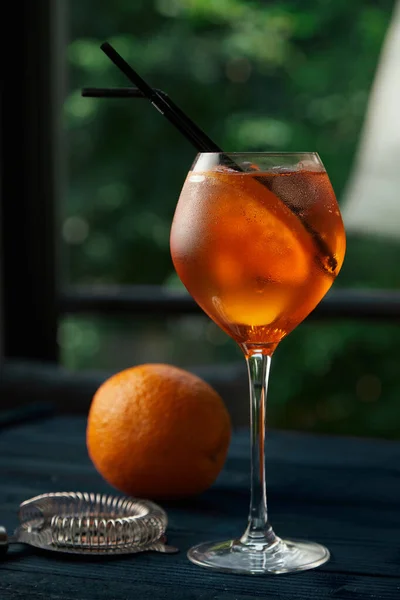 Aperol Spritz en el fondo de la institución con una naranja — Foto de Stock