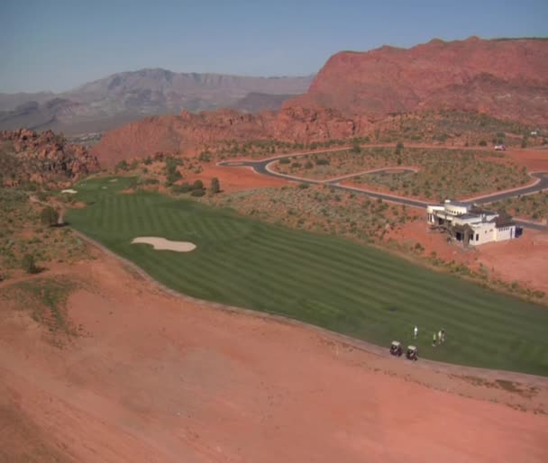 Aerial shot of golfers on desert course — Stock Video