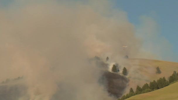 Un hélicoptère de lutte contre l'incendie vole vers le coucher du soleil — Video