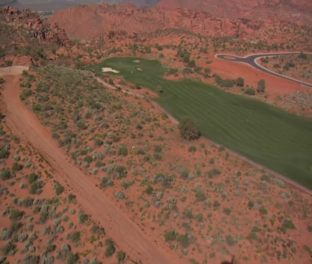 Aerial shot of golfers on desert course — Stock Video