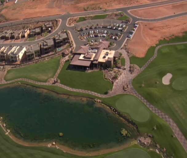 Aerial shot of clubhouse on desert course with lake — Stock Video