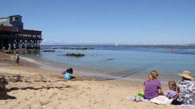 arka planda iskelesi ile kumlu plaj