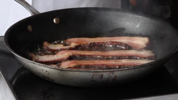 Приготовление бекона на сковородке — стоковое видео