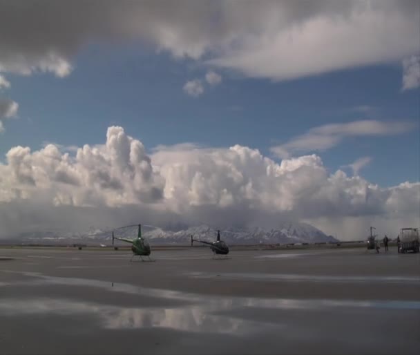 Zeitraffer von Hubschraubern auf der Landebahn und geschwollenen Wolken — Stockvideo