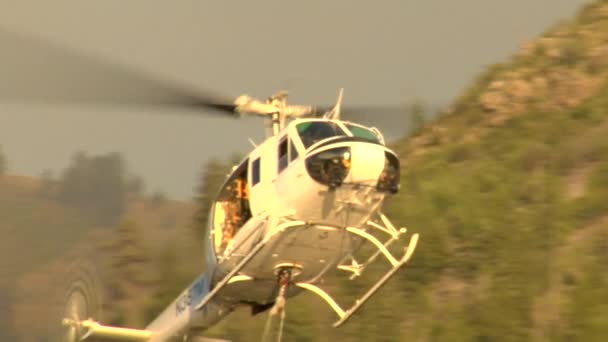 Helicóptero de combate a incêndios coleta água do rio — Vídeo de Stock