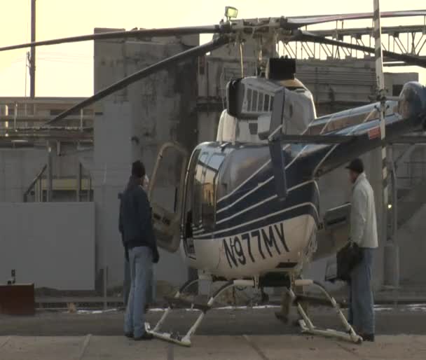 Mannen inspecteren stationaire helikopter — Stockvideo