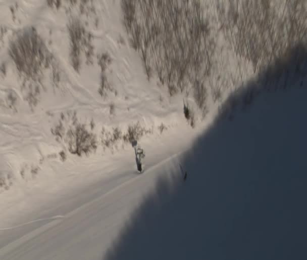 Aerial shot of skiers entering shadow — Stock Video