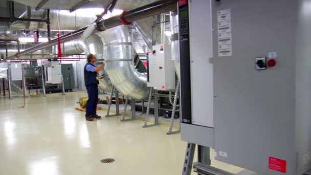 Man takes readings on large air ducts — Stock Video